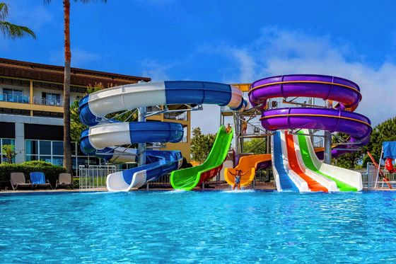 Parc d'attractions aquatiques piscine extérieure enfants montent sur des toboggans en fibre de verre