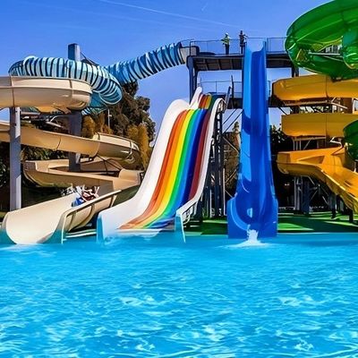 Enfants dans la piscine au sol, sur le toboggan en fibre de verre pour le parc aquatique